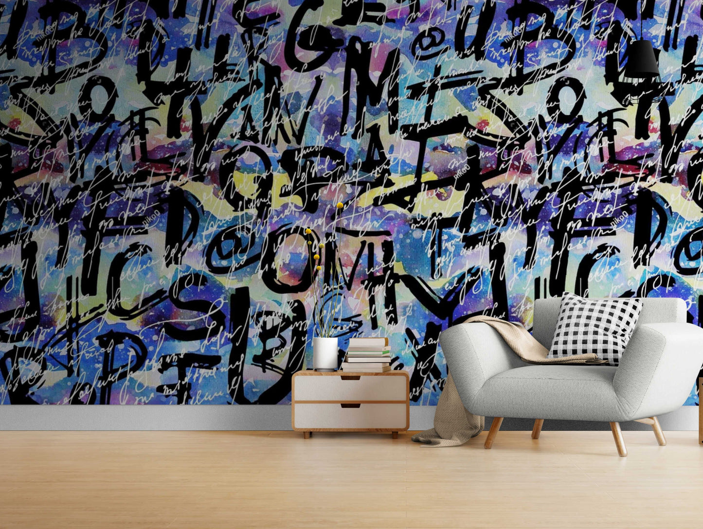 An image of a wallpaper with an abstract graffiti-inspired design in various colors, including shades of pink, blue, purple, and green. The design features irregular shapes and lines that create a chaotic yet artistic effect. The wallpaper is self-adhesive, making it easy to install without the need for additional glue or paste.