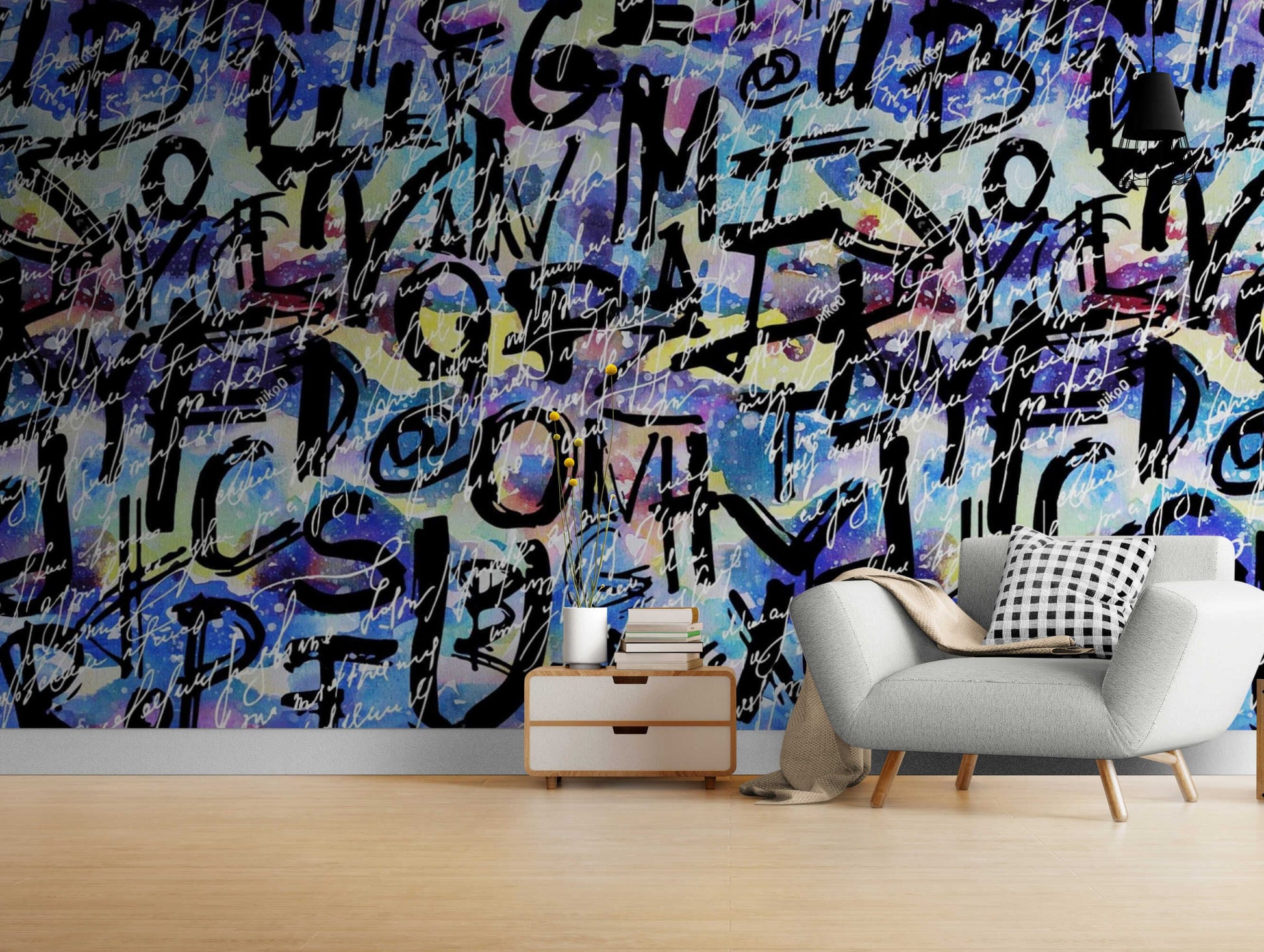 An image of a wallpaper with an abstract graffiti-inspired design in various colors, including shades of pink, blue, purple, and green. The design features irregular shapes and lines that create a chaotic yet artistic effect. The wallpaper is self-adhesive, making it easy to install without the need for additional glue or paste.